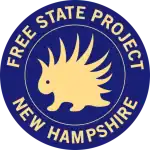 A blue circular logo with a yellow porcupine in the center. The words “FREE STATE PROJECT” are curved along the top, and “NEW HAMPSHIRE” is curved along the bottom.